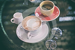 Coffee has a heart-shaped cream, a white cup with tea, chocolate