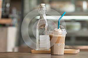 Coffee with ice capucino frape cup drink on wooden desk with blurred coffee shop photo