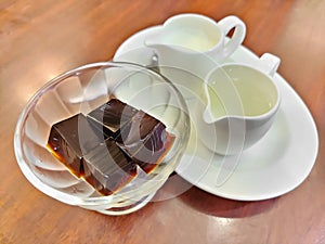 Coffee jelly, jelly dessert flavored made from black coffee and gelatin, serving with milk and syrup. Refreshing dessert for