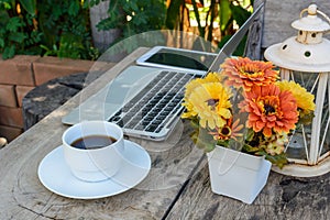 Coffee, laptop on wood floor with flower