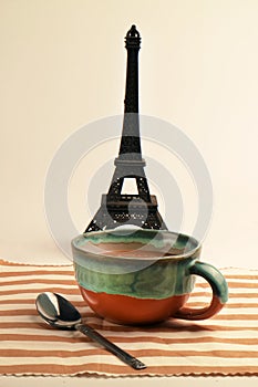 Coffee latte cappuccino in a cup on striped cloth with eiffel tower miniature french background