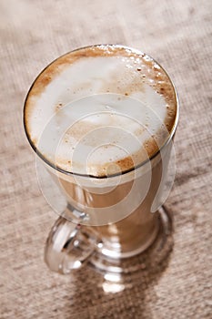 Coffee latte with closeup froth on rustic photo