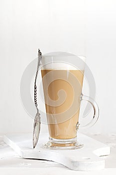 Coffee latte with frothy milk in tall glass photo