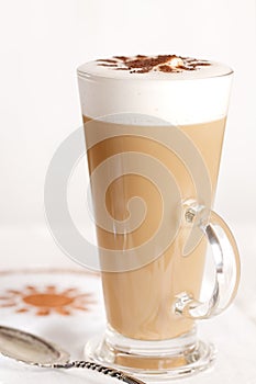 Coffee latte with frothy milk in tall glass