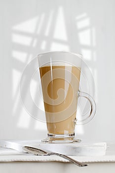 Coffee latte with frothy milk in tall glass photo