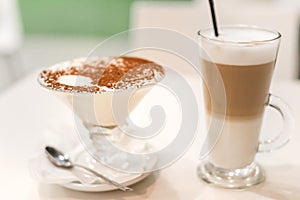 Coffee latte with frothy milk in tall glass, rustic style, white background