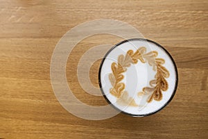 Coffee latte in glass cup on brown table in cafe