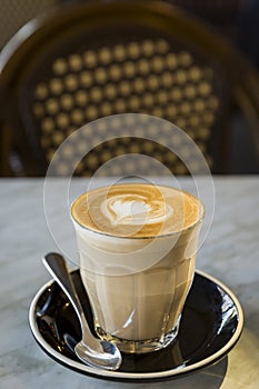 Coffee latte in glass cup with love heart shape latte art in milk froth