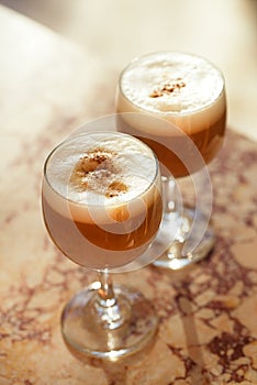 coffee latte in tall glasses with morning sun in summer cafe background