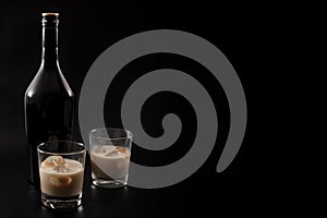 Coffee liqueur and alcoholic beverages based on milk and whiskey concept with Irish cream bottle and glasses with ice isolated on