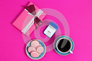 Coffee with macarons and ring on a pink background. An offer of marriage, box which give ring. Top view, toned image