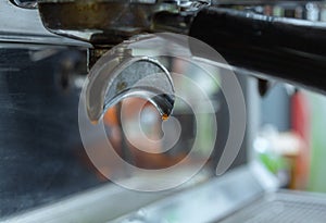 Coffee machine console.The groove of the coffee machine handle. The liquid that is dripping the espresso.