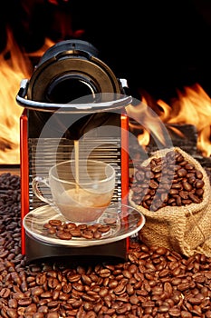 Coffee machine with cup of espresso near fireplace