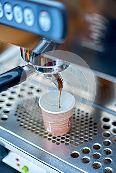 Coffee machine preparing fresh coffee and pouring into paper cup