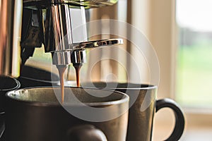 The coffee machine makes coffee in two mugs