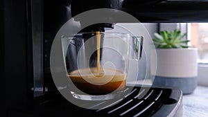 Coffee machine making espresso in glass transparent coffee cup.