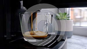 Coffee machine making espresso in glass transparent coffee cup.