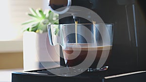 Coffee machine making espresso in glass transparent coffee cup.