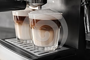 Coffee machine making latte, closeup