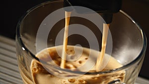 Coffee machine pouring espresso in cup extremely close-up