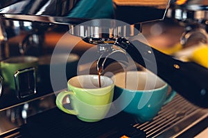 Coffee machine preparing espresso and pouring into colored cups photo