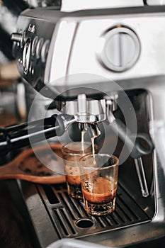 Coffee machine preparing fresh coffee and pouring into red cups at restaurant, bar or pub