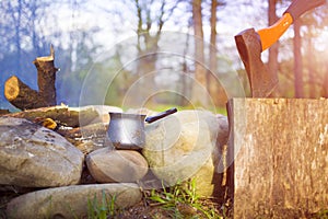 A coffee maker and an axe near a fire.