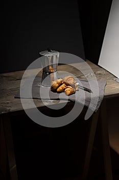 coffee maker and croissants on wooden table
