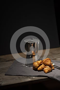 coffee maker and croissants on wooden table