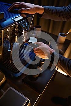 Coffee maker with portafilter preparing aromatic drink with coffee machine