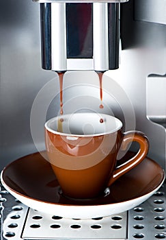 Coffee maker pouring fresh espresso coffee photo