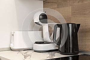 coffee makers, kettles and toaster on the marble countertop