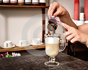 Coffee making women`s hands pour coffee into a glass