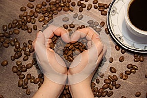 Coffee mania. Love. Hands shaped like heart. Coffee beans in the palms