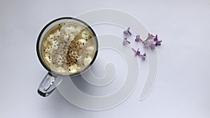 Coffee with marshmallows and cinnamon. Blows off heart-shaped lilac flowers
