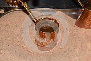 Coffee in metal Turkish traditional cup, being served in a traditional cafe bar in Istanbul, Turkey