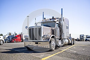 Coffee with milk big rig classic stylish semi truck tractor with extended cab and chrome parts standing along on truck stop