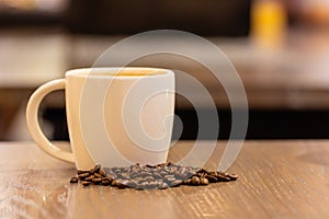 Coffee milk in a cup with coffee bean on wooden table in coffee shop.