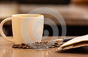 Coffee milk in a cup with coffee bean on wooden table in coffee shop.