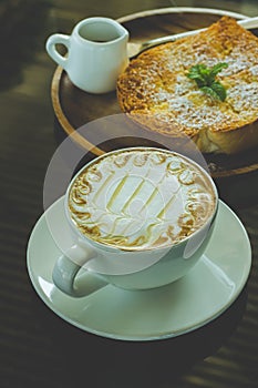 Coffee, Milk froth and toast on the morning table.