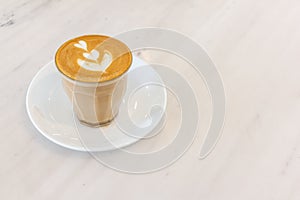 Coffee milk in a glass on marble table in coffee shop.