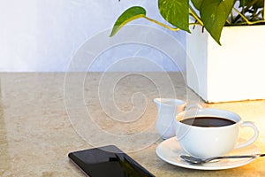 Coffee with milk jug on marble top table.