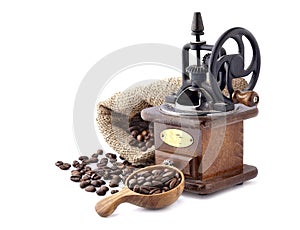 Coffee mill with Coffee beans in a wooden spoon on white background