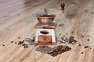 Coffee mill at wooden floor with hearth