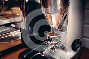 Industrial coffee milling machinery pouring fresh coffee into tamper roaster photo