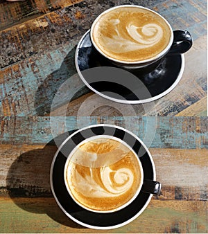 Coffee Montage in black cup on timber table