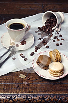 Coffee mood: cup of coffee, coffee beans and multicolored macaroons