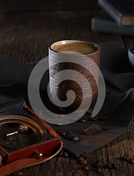 Coffee mug and antique objects in dark background