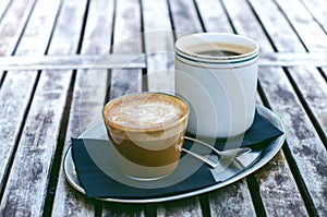 Coffee mug and cake on a wooden vintage table. Hipster concept. Woman drink a coffee. Cups of americano and macchiato.