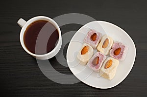 Coffee mug, saucer with Turkish Delight on a black table